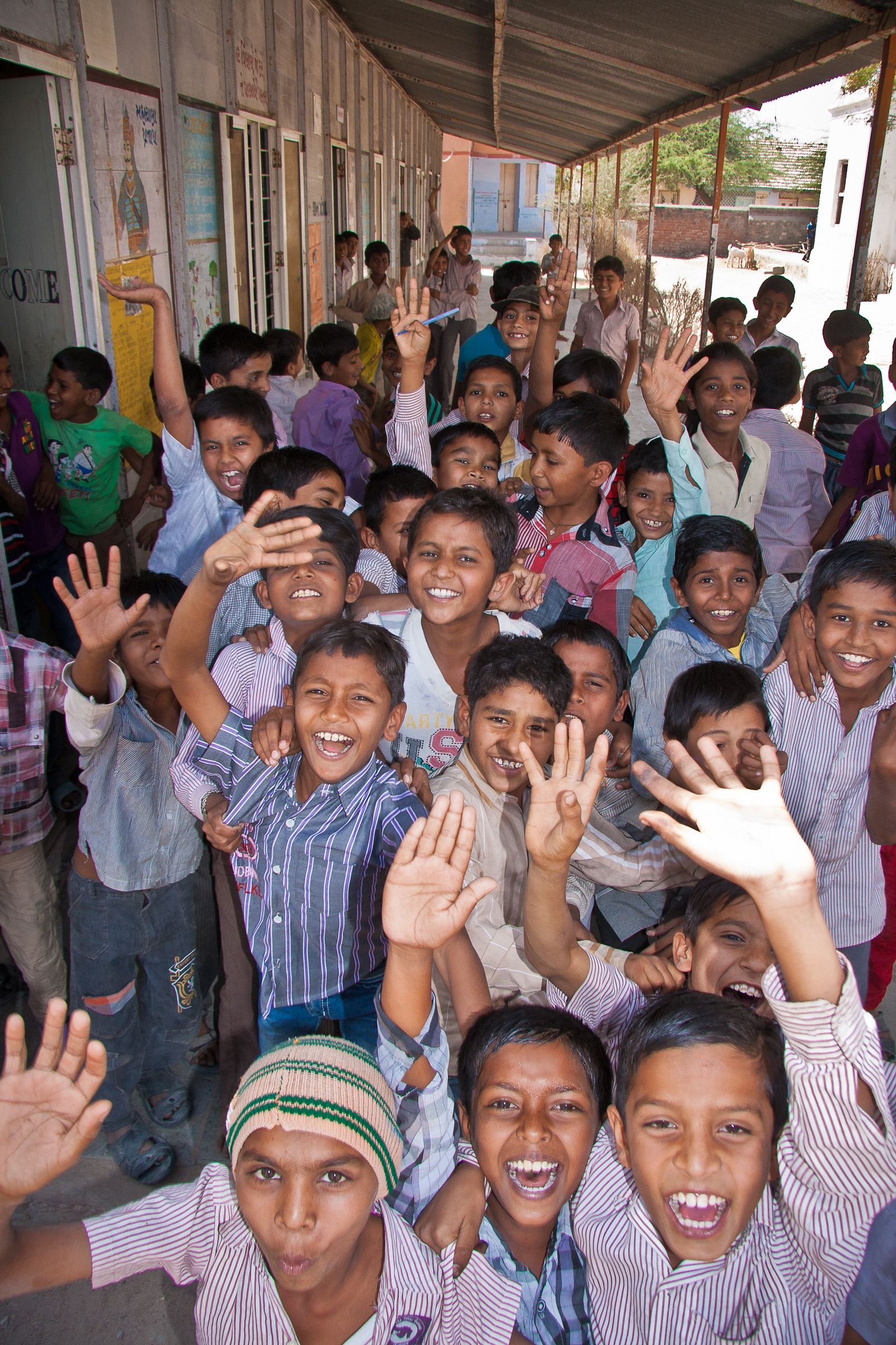 Children welcoming seldom seen travellers in their little school